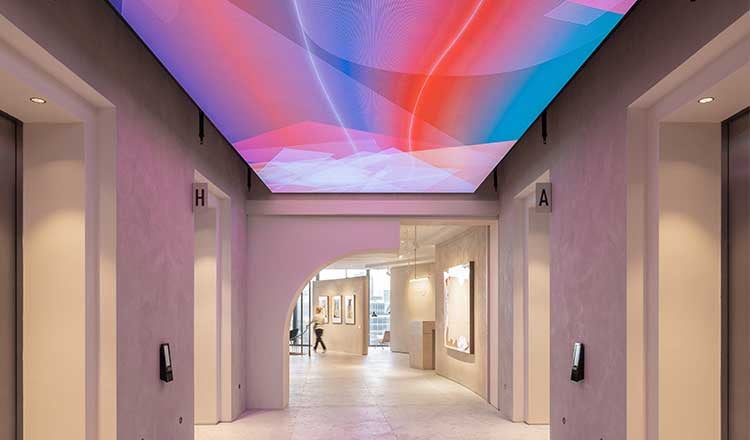 Interior of 22 Bishopsgate, London. Hallway with digital display fixed to ceiling. 