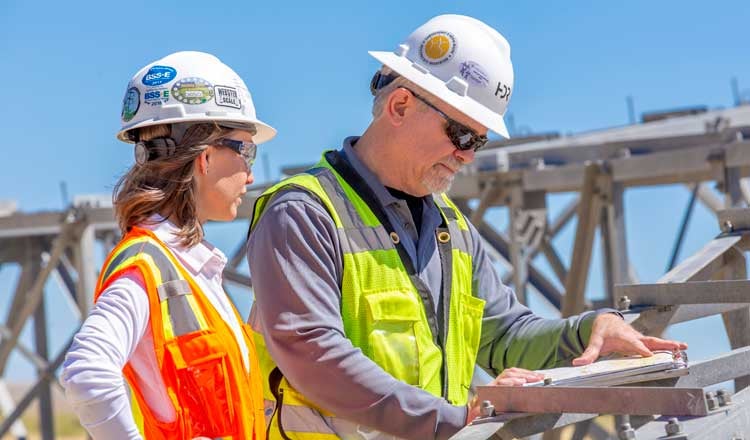 2 employees on worksite wearing hard hats