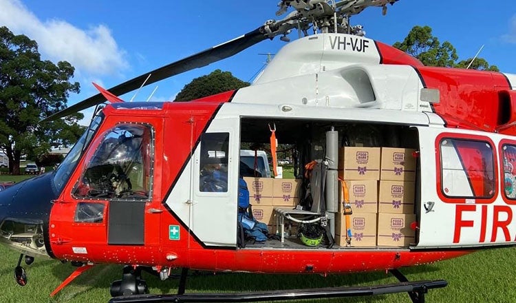 A helicopter delivers food and water to flood victims