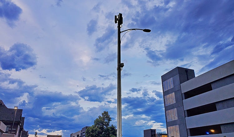 5g infrastructure on streetlight with clouds behind