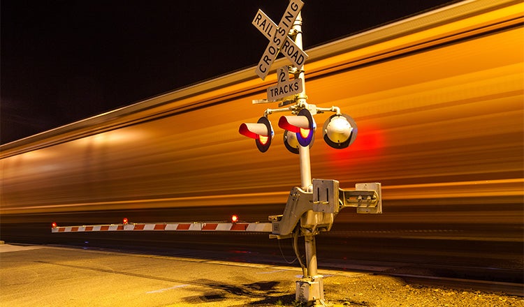 train going through railroad crossing