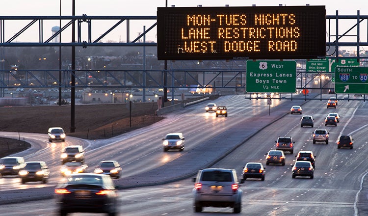 variable messaging sign over highway at dusk