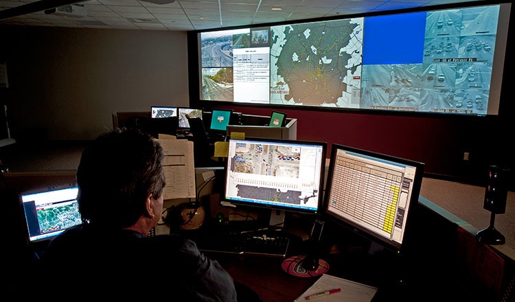 person in front of monitors in traffic control room