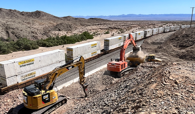 construction vehicles working next to train track