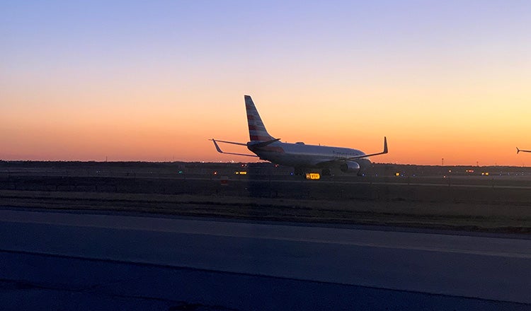 Airplane on runway at sunset