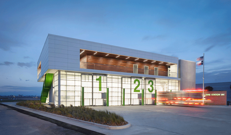 Exterior of the City of Galveston Fire Station with a blurry fire truck leaving the facility.