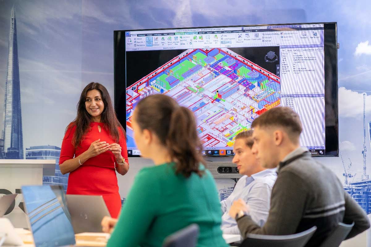 Employees presenting at HDR London Blackfriars Office. Large display screen in background.