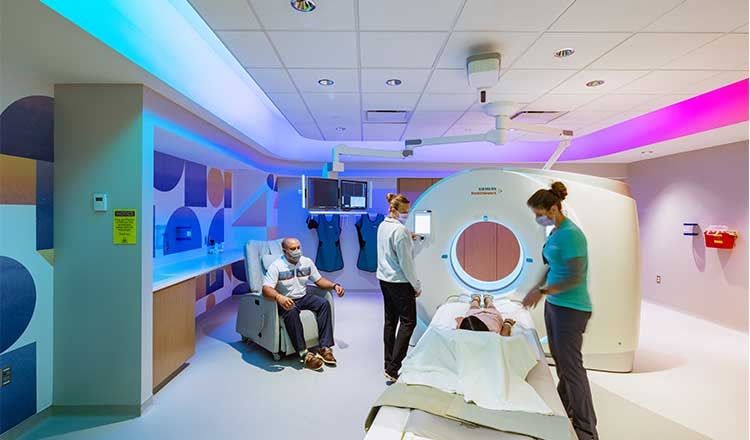 Interior of Hospital Bed and Treatment Room at The Hubbard Centre for Children. Nurse and patient with visitors in view.