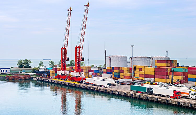 containers at port with cranes on wharf