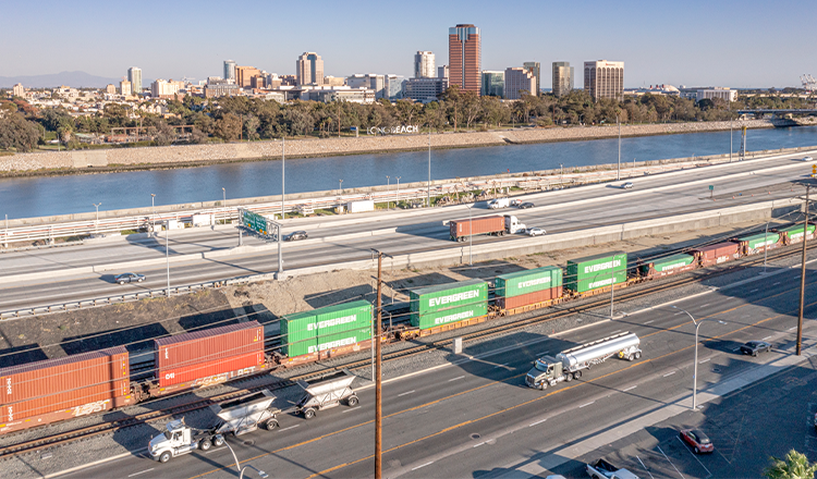 freight train pulling containers next to highway