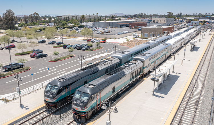 trains waiting for passengers at station in sunshine