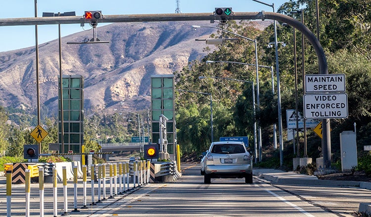 car on highway with sign advising of video enforced tolling