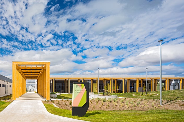 exterior view of cherry creek youth justice precinct depicting outdoor signage and a colorful welcoming walkway with overhead beams