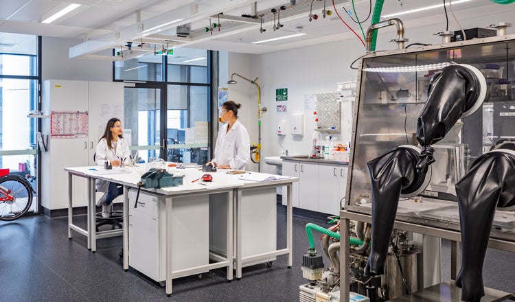 scientists collaborating at a work desk inside of a lab
