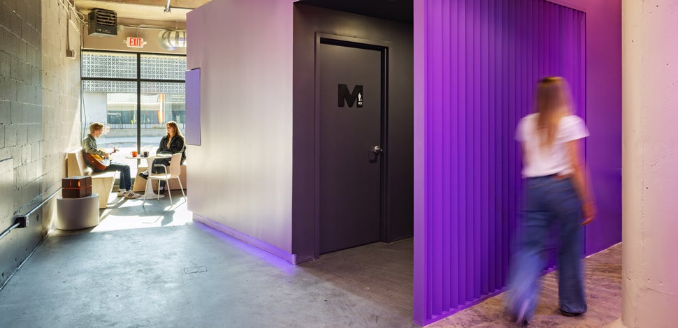 Purple wall, person passing, people by window