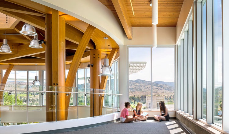 Students sitting by the window in a school hallway, mass timber interiors