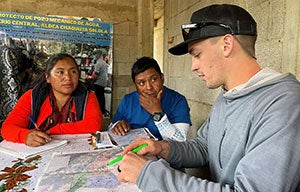 Luke Thompson consults with local community members on an Engineers Without Borders volunteer trip.