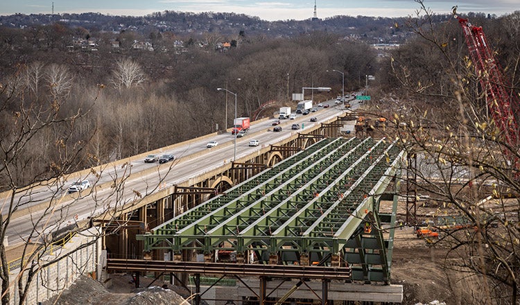 bridge with traffic next to bridge under construction