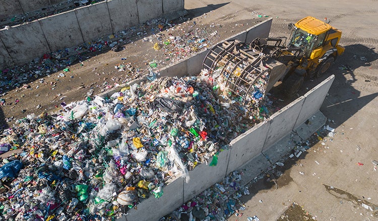A machine pushes recycling into a pile