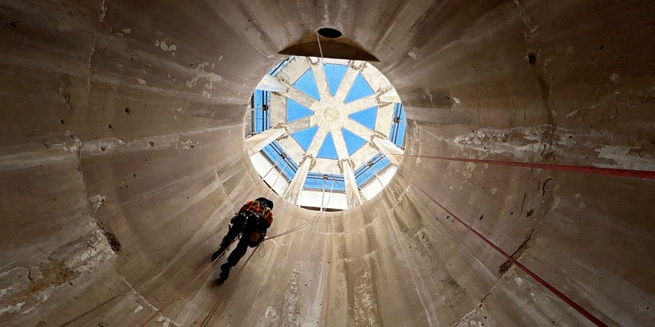 HDR employee uses ropes to access a spillway structure for inspection