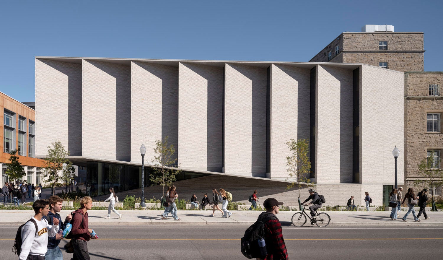 Students walking in front of a university building with limestone fins for sunshading