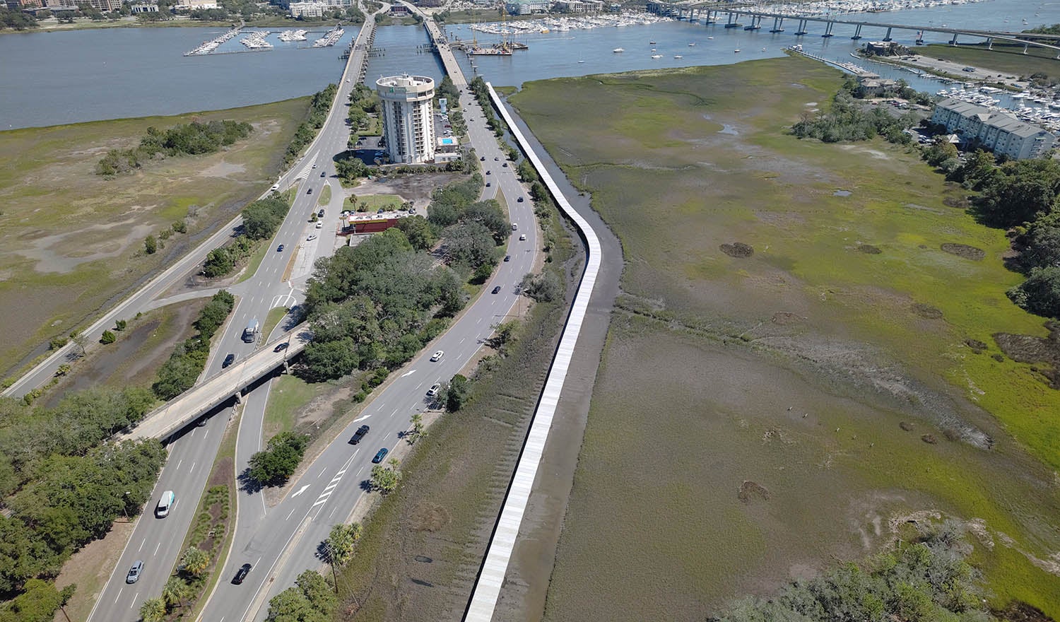 aerial view of roads with traffic with bridges over river in background